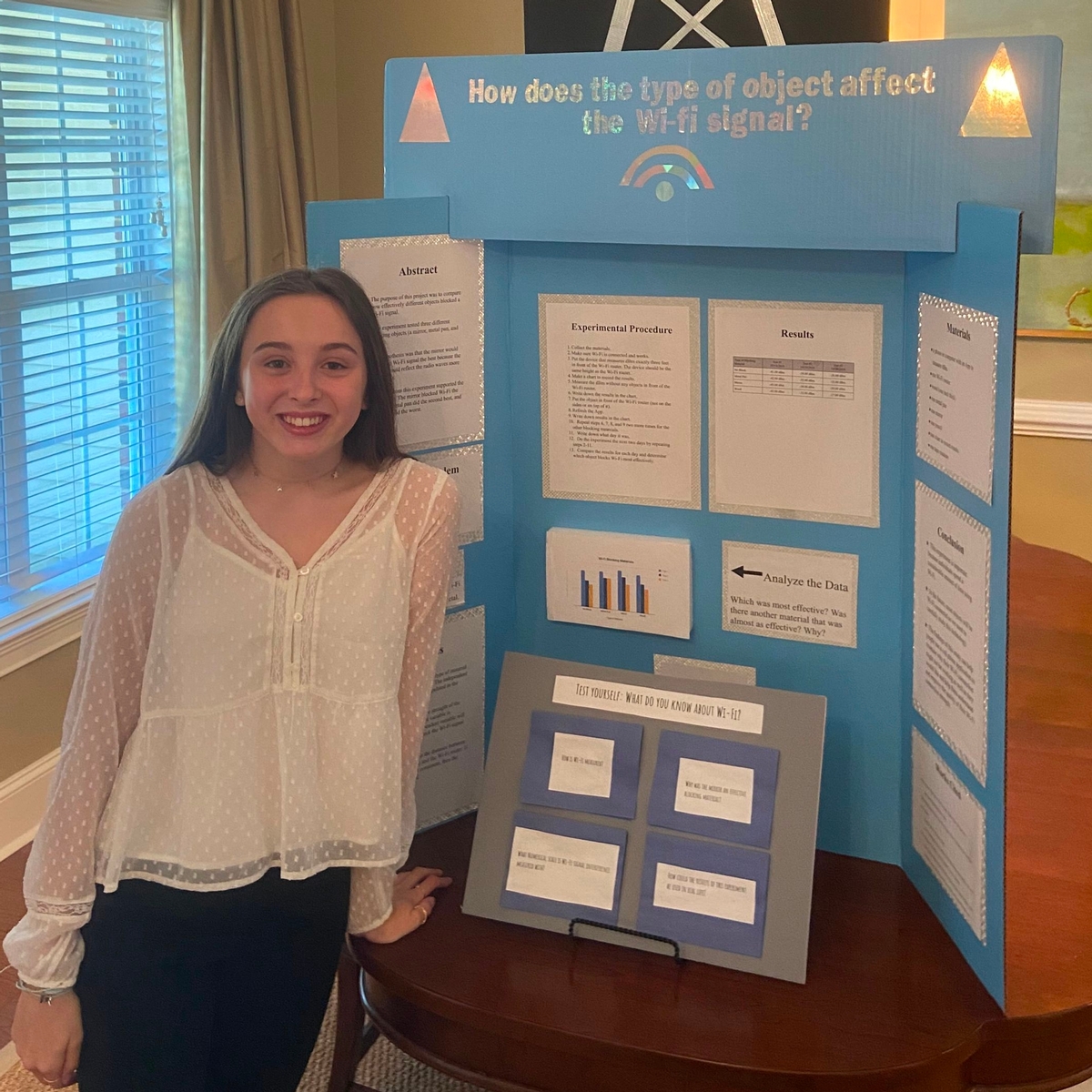 Monetti Stands in Front of Her Second Place Science Fair Project